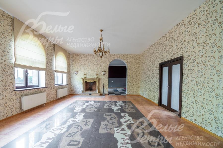 Гостиную украшают бронзовая люстра, камин, напольное панно из гранита 