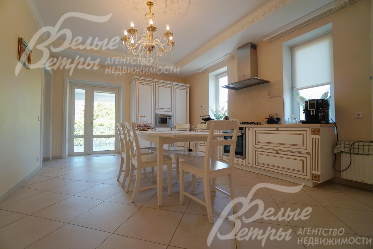 Кухня-столовая с выходом на террасу 22 кв.м. Установлена итальянская кухня с фасадами из массива дерева, столешницей из искусственного камня, встроенной техникой NEFF.