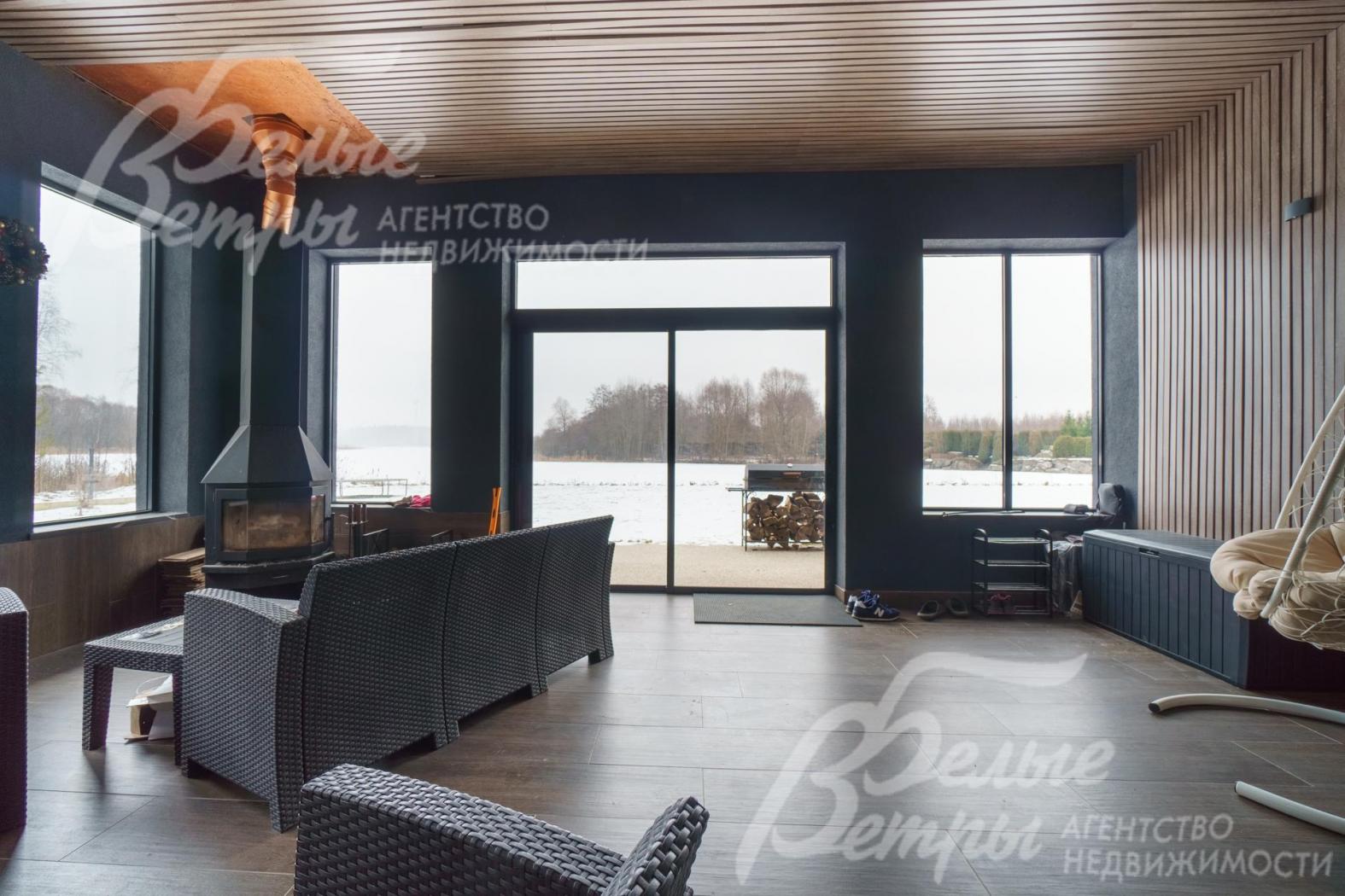 С террасы выход через раздвижное остекление на участок к воде. Камин и подогрев пола позволяют использовать в любое время года.