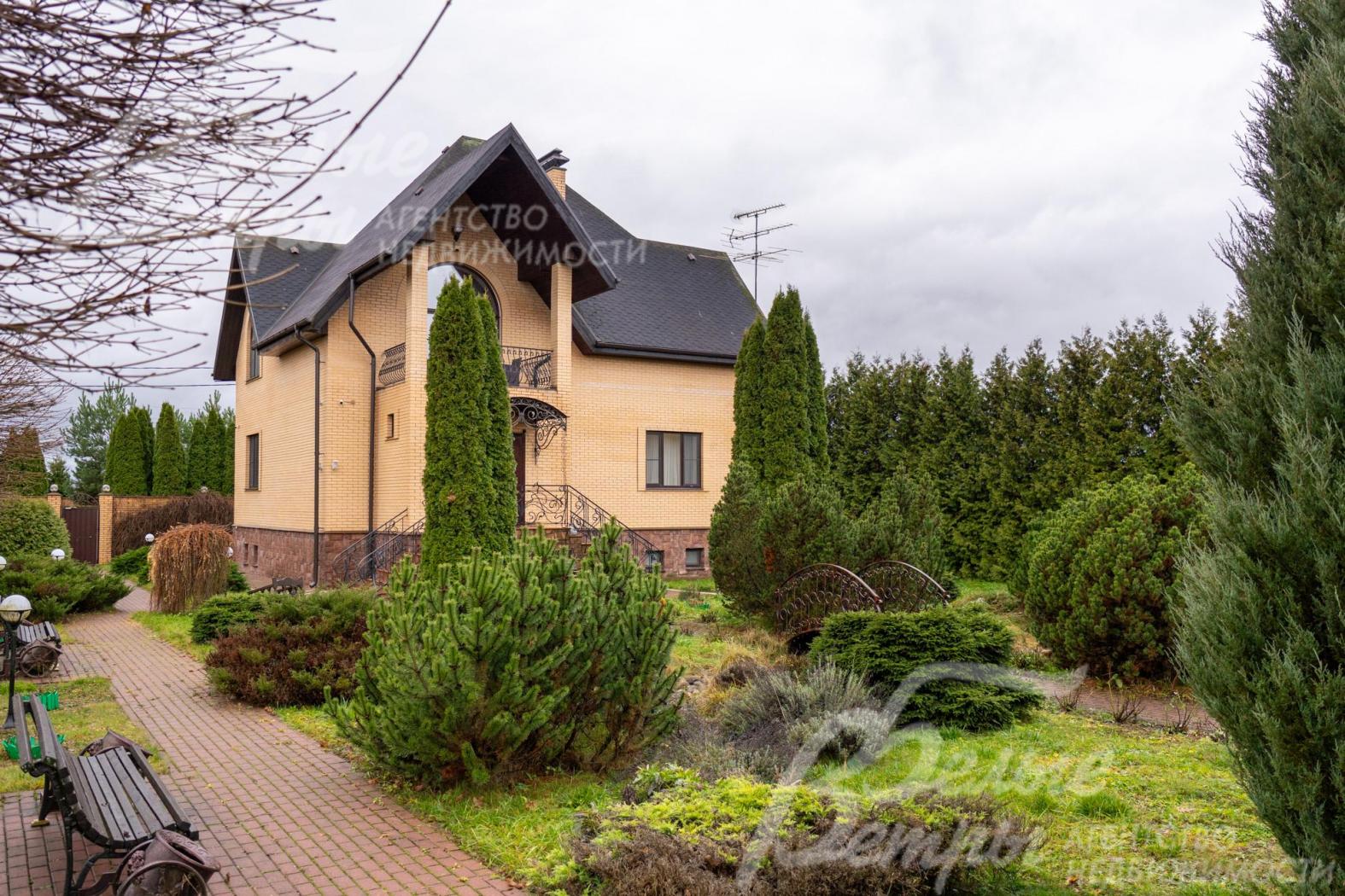 От калитки к дому и другим строениям ведёт аккуратная дорожка с зонами для отдыха с садовыми скамейками