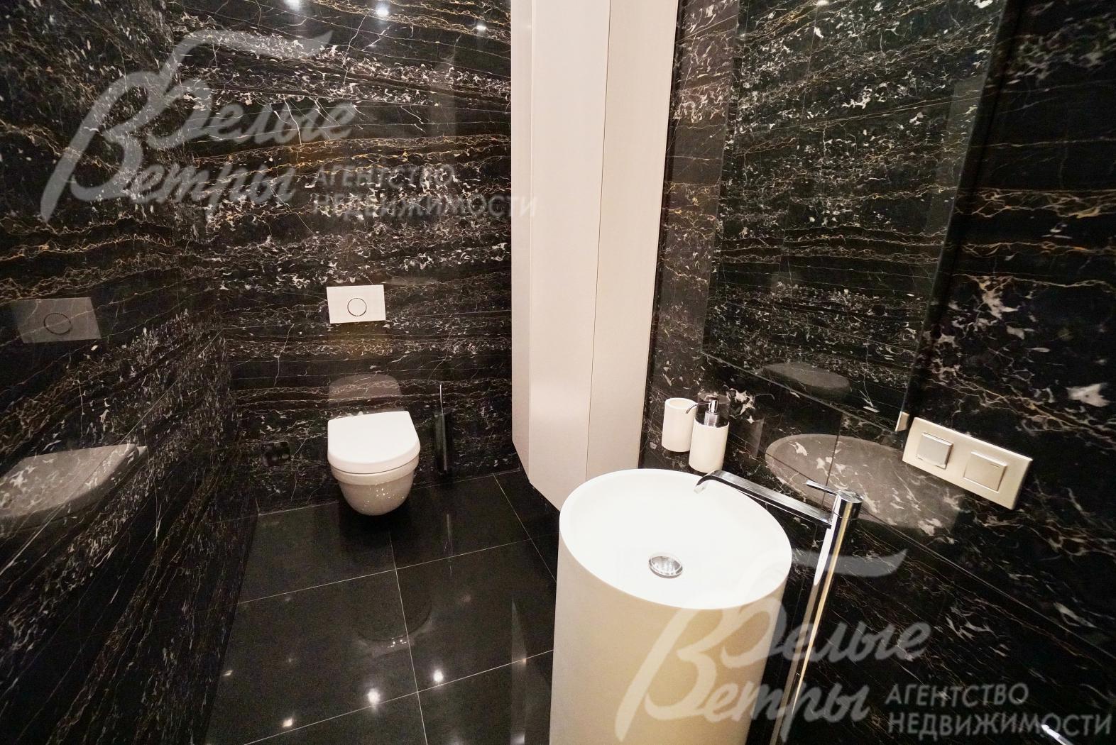 Санузел в зоне бассейна облицован черным мрамором