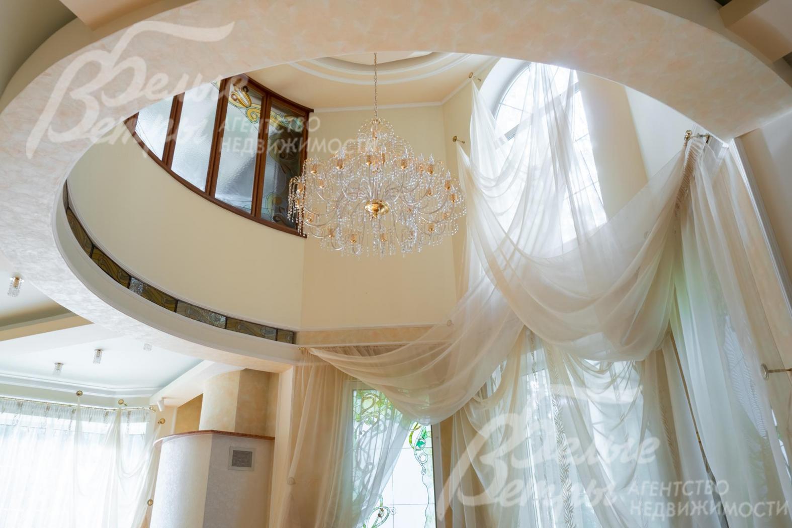 Гостиную украшают воздушные лёгкие шторы и дорогостоящая люстра