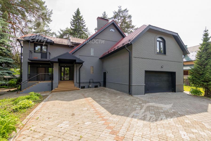 Меблированный дом, построенный в классическом стиле, с элегантной облицовкой серым кирпичом