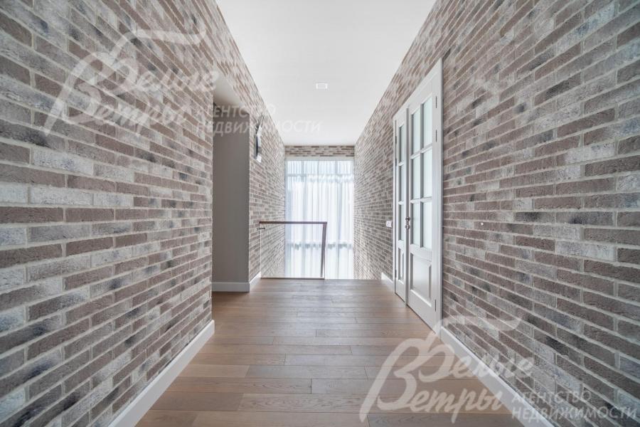 Холл второго этажа наполнен естественным светом благодаря панорамному окну на лестничном пролёте