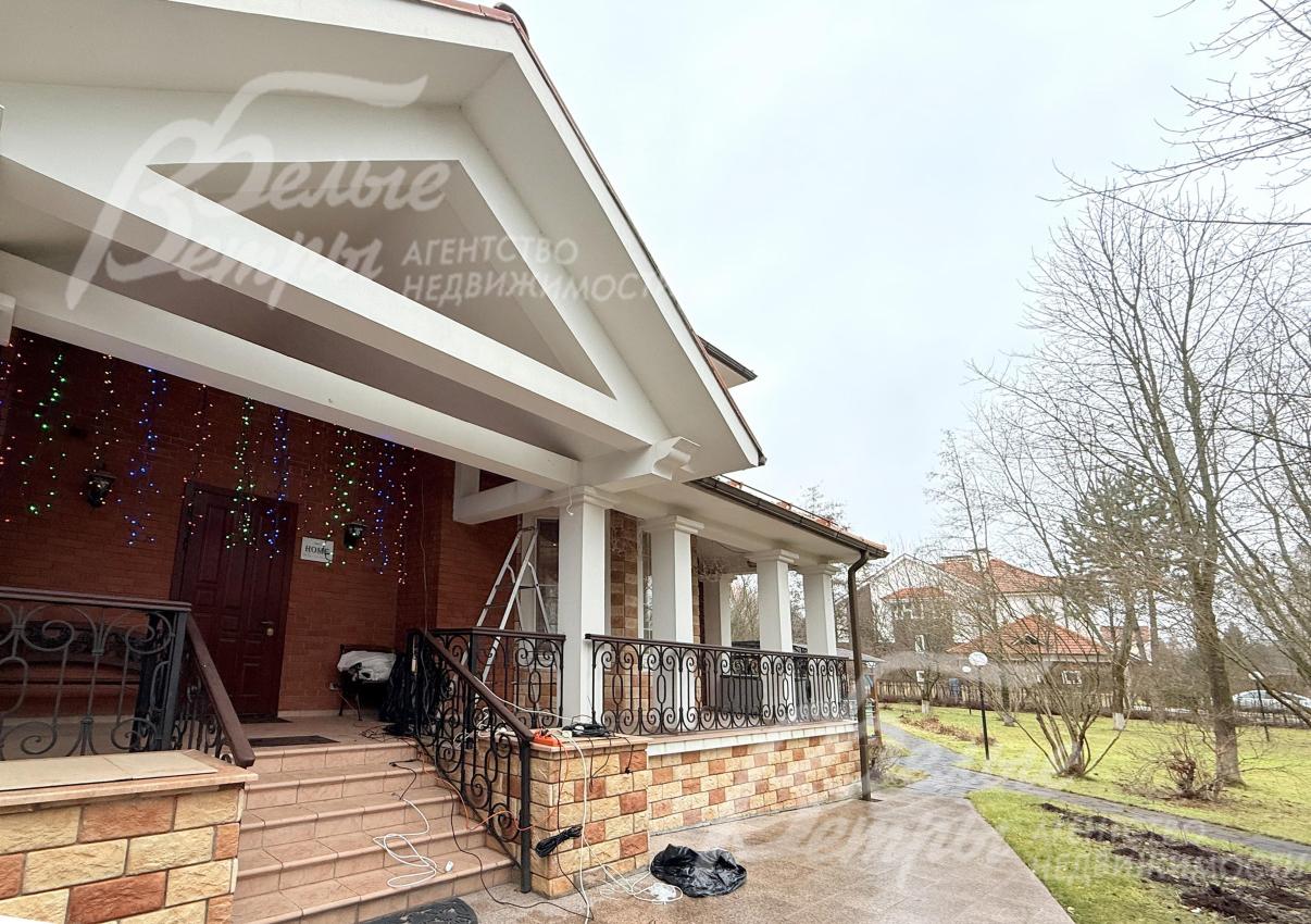 Архитектура террасы - с массивными белыми колоннами, крышей с широким свесом, перилами из кованого металла