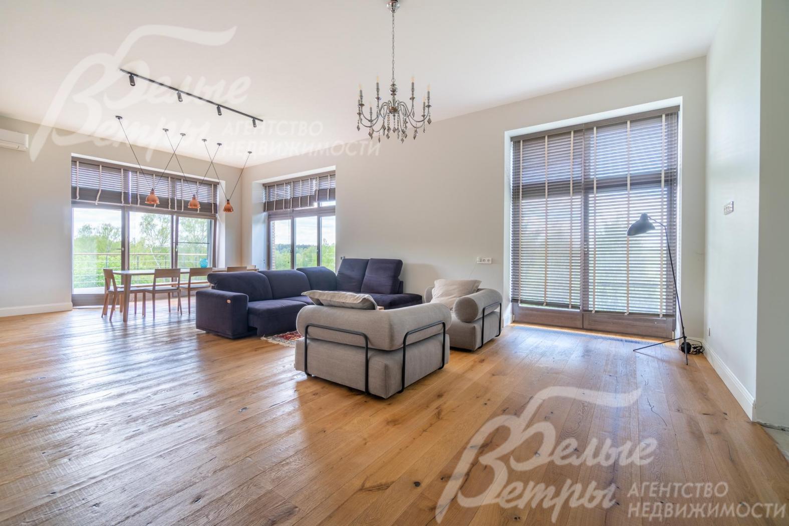 В гостиной-столовой - большие деревянные окна в пол: помещение наполнено естественным светом