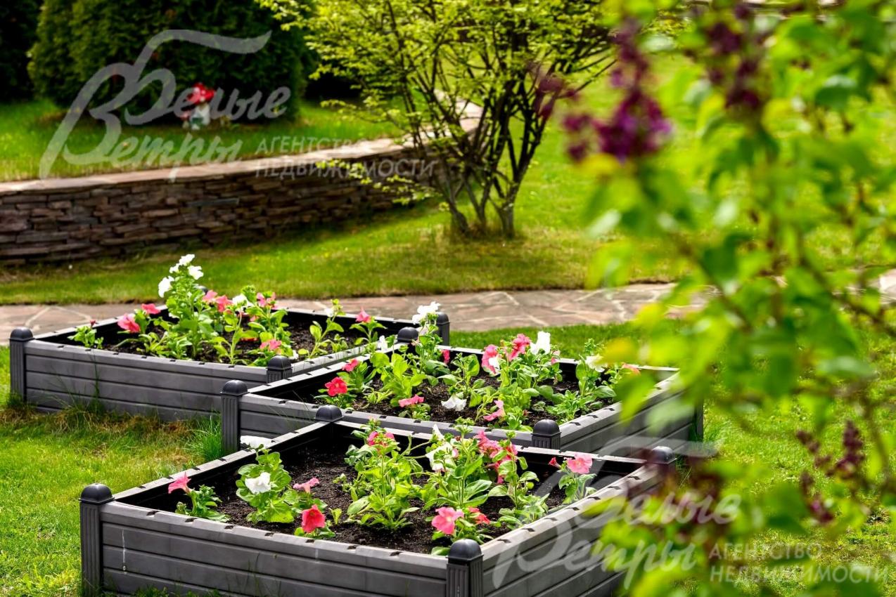 На благоустроенном участке цветники и клумбы. 