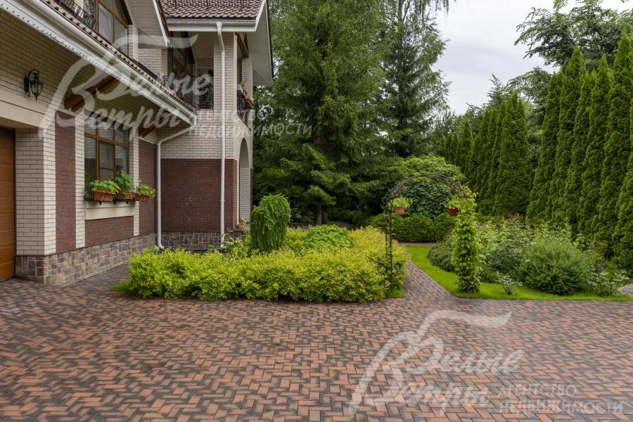 Дорожки, зона открытой парковки и подъезда к гаражу вымощены эффектной немецкой клинкерной брусчаткой