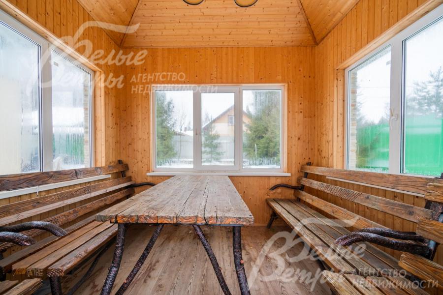 Закрытая беседка с садовой мебелью из дерева