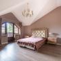 Элегантная спальня на втором этаже с мансардной крышей и с выходом на террасу