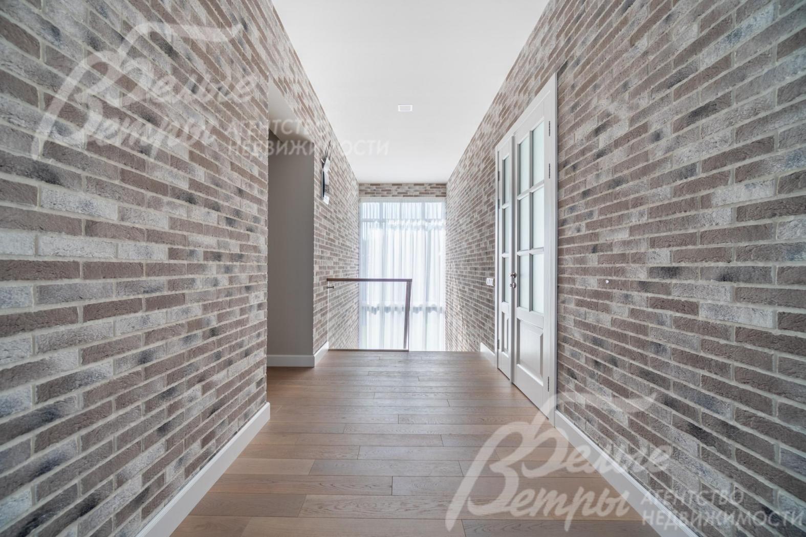 Холл второго этажа наполнен естественным светом благодаря панорамному окну на лестничном пролёте