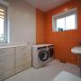 Постирочная на втором этаже со стиральной и сушильной машинами и гладильной доской